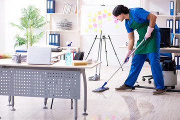 Male handsome professional cleaner working in the office 