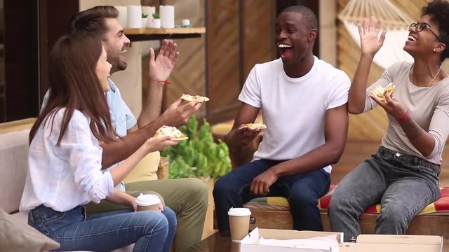 Happy diverse friends laughing sharing pizza at restaurant terrace outdoor
