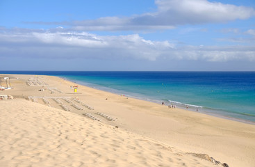 View from above on beach with golden sand and ocean in Morro Jable, Fuerteventura.