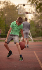 Fototapeta premium One boy, exercising dribbling ball between his legs.
