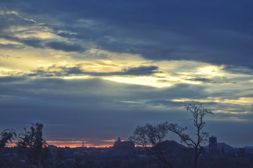 Skyline view of cityscape with sunlight and flare in warm light color tone.