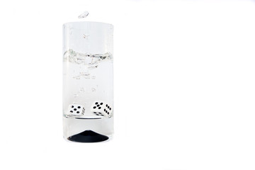 Dice falling in a glass of pure water. Сompulsive gambling, problem gambling.