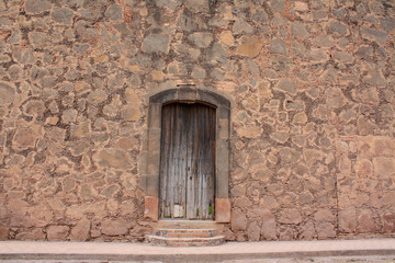 Fototapeta na wymiar Ancient adobe and stone facade in a mexican house