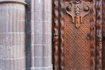 Detail of a beautiful wooden door and a stone column in a colonial house