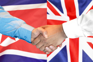 Business handshake on the background of two flags. Men handshake on the background of the North Korea and United Kingdom flag. Support concept
