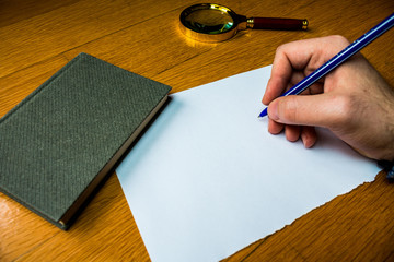 Man writing blank document wooden table magnifying glass electronic device Design business concept Empty copy text for Web banners promotional material mock up template