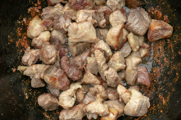 step-by-step process of cooking pilaf in a cast iron cauldron