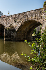 Fototapeta na wymiar Along the quays under an old vaulted bridge in a French province in Semur