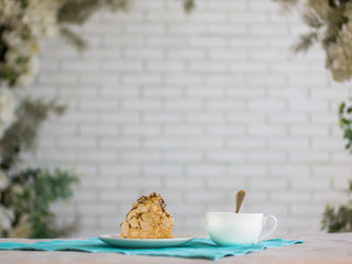a piece of cake and a Cup of tea, a white brick wall and plants