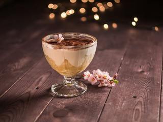 chocolate cream with coffee dessert in a glass container and the hand with a spoon