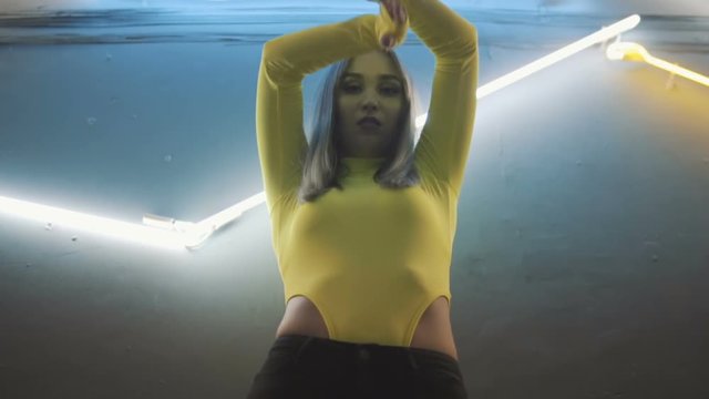 Fashionable girl in body dancing on the background of the neon lapms