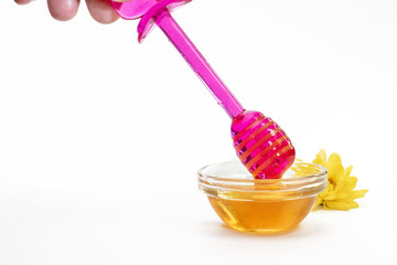 purple honey stick picks up honey on white background