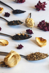 Variety of dry tea in spoons on the white. An assortment of dry tea. Different herbal wellness dried teas. Dry tea leaves on white
