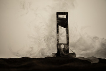 Horror view of Guillotine. Close-up of a guillotine on a dark foggy background.