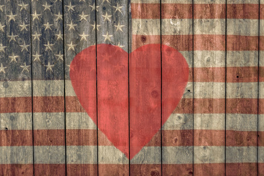vintage american flag and red heart painted on  weathered barn wood siding