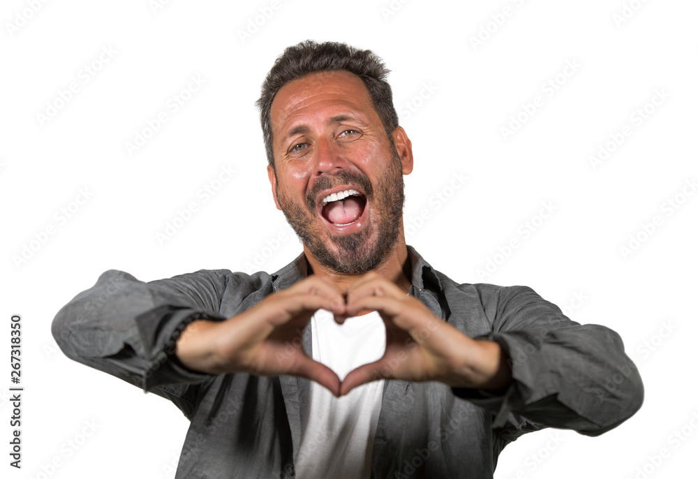 Wall mural portrait of young happy and attractive man hugging himself smiling positive and charming doing hand heart shape sign with fingers isolated on white background