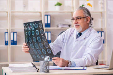 Aged male doctor radiologist in the clinic 
