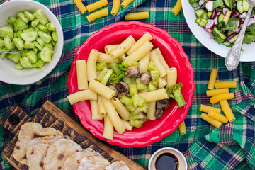 Pasta with vegetables, Italian macaroni on plate with soy sauce and fresh salad. Vegetarian vegan healthy food. Top above view