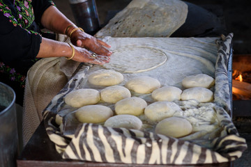 Close up Arabian old woman hand cooking flatbread or laffa or pita bread for Ramadan Arabic holiday.