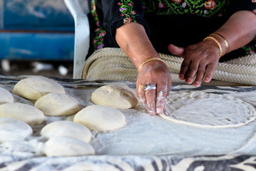 Close up of old Arab woman hands kneading fresh dough for Taboon bread or Lafah is a Middle Eastern...