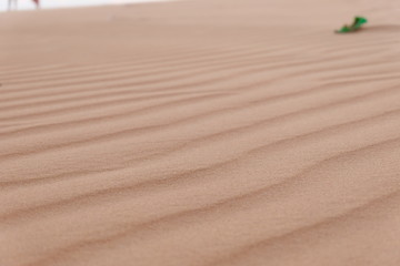 young woman relaxing at white sand dunes on sunset background