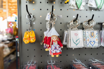 Dutch souvenirs from Holland being sold in a gift shop, with wooden clog keychains, a Dutch milkmaid keychain and flower keychains.