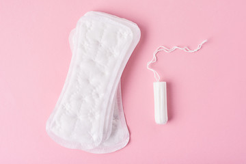 Sanitary pad and menstrual tampon on a pink background
