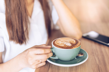 woman in a cafe drinking coffee .Portrait of Asian woman smiling in coffee shop cafe vintage color tone