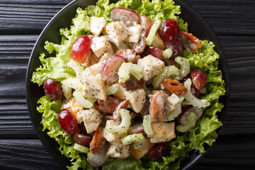 Recipe for delicious Sonoma salad with chicken breast, celery, pecans and grapes covered with sauce close-up. horizontal top view