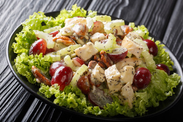 Sonoma salad with chicken, celery, Pecan and grapes served with green lettuce close-up on a plate on the table. horizontal