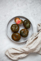 Organic Tomato Marmande black  on marble backgroun with copy space. Vegan product