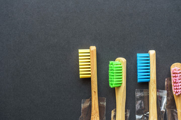 bamboo toothbrushes in plastic bags on dark rough background. plastic-free concept