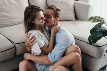 Beautiful young couple bonding and smiling while lying in the bedroom