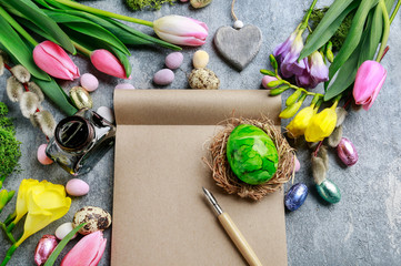 Open paper notebook, colorful flowers and easter eggs.