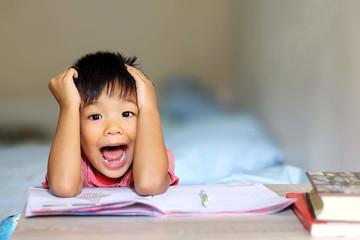 Naklejka premium Asian student child boy have a headache and he feeling stressed because he get a lot of homework. Education and kid concept.