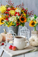Beautiful white lantern, flowers and pumpkins on the table