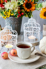Beautiful white lantern, flowers and pumpkins on the table