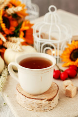 Cup of tea and beautiful autumn floral decorations on the table.