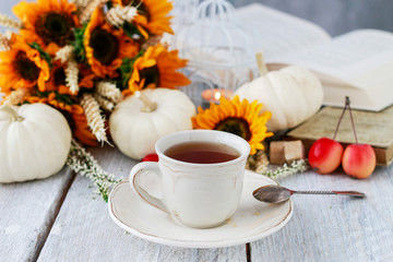 Cup of tea and beautiful autumn floral decorations on the table.