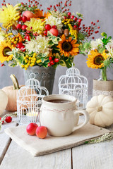 Cup of tea and beautiful autumn floral decorations on the table.