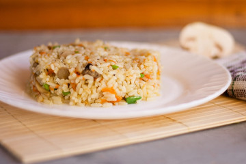 White plate with spicy pilaf with mushrooms