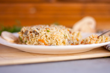 White plate with spicy pilaf with mushrooms