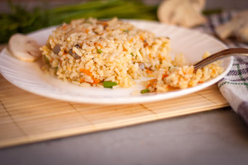 White plate with spicy pilaf with mushrooms