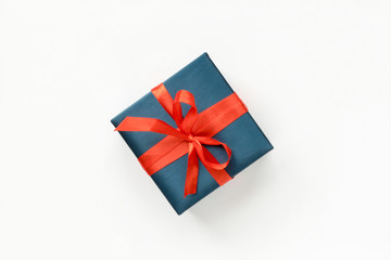 Blue Gift box with red ribbon on white background. Top view. Copyspace