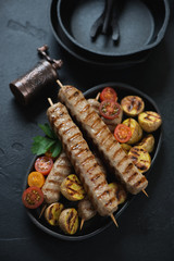 Grilled chicken kebabs with mini potatoes and cherry tomatoes, vertical shot, closeup