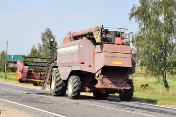 Modern combine harvester moves in a column by road