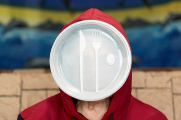 Plastic waste and man. The concept of modern man's dependence on plastic products.