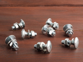 Set of screws, nuts and washers on a brown background. Industrial theme