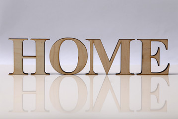 word "HOME" is made from wooden letters isolated on a white background
