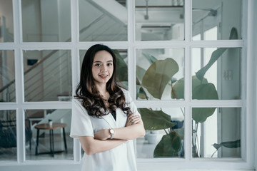 beautiful asian woman smiling while working herself in cafe